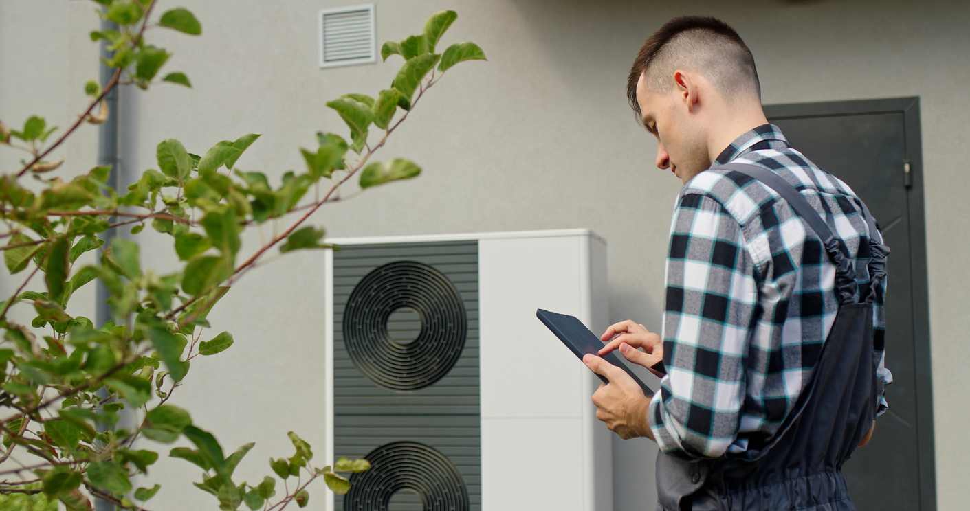 technician performing maintenance on a heat pump