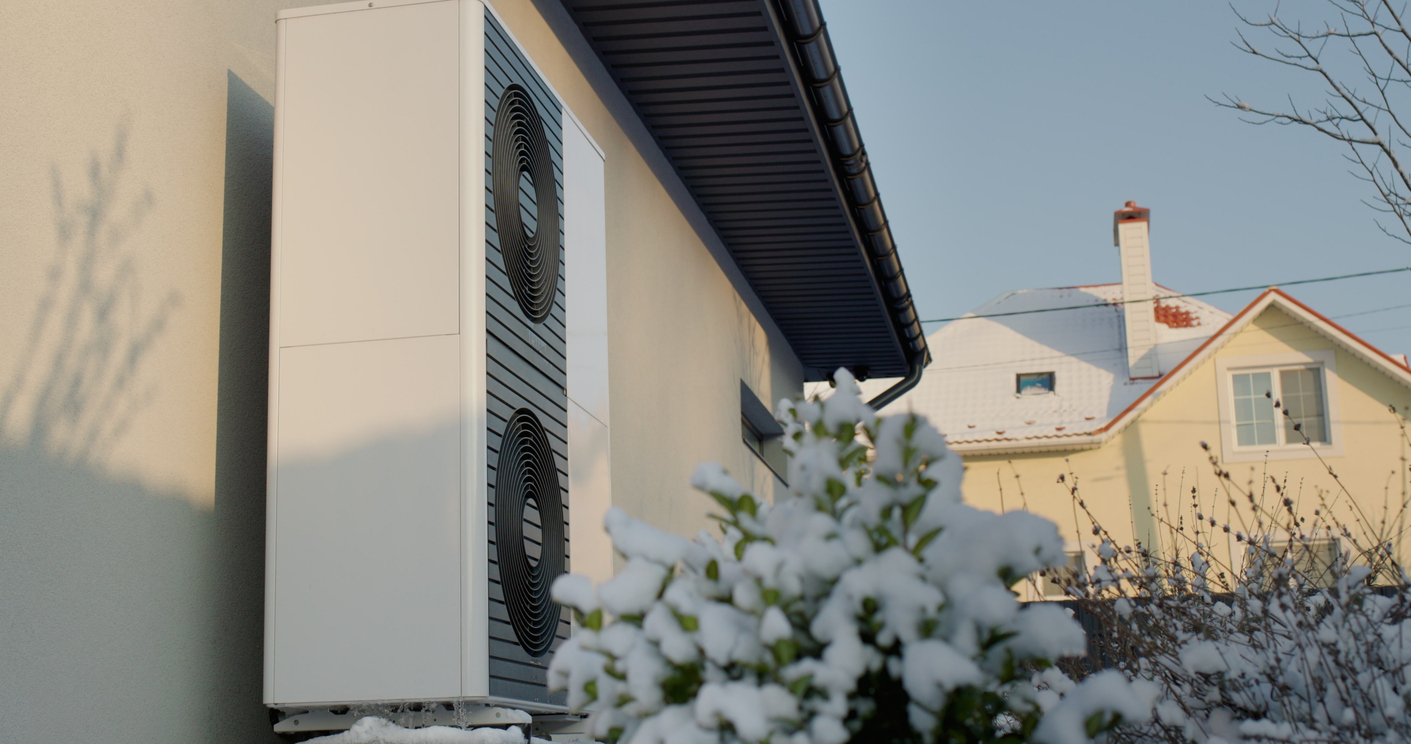 heat pump fitted on the outside of a house, wintry sky